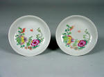 Pair of Yongzheng famille rose (fencai) saucers decorated with floral sprays of peony and chrysanthemums and a bat